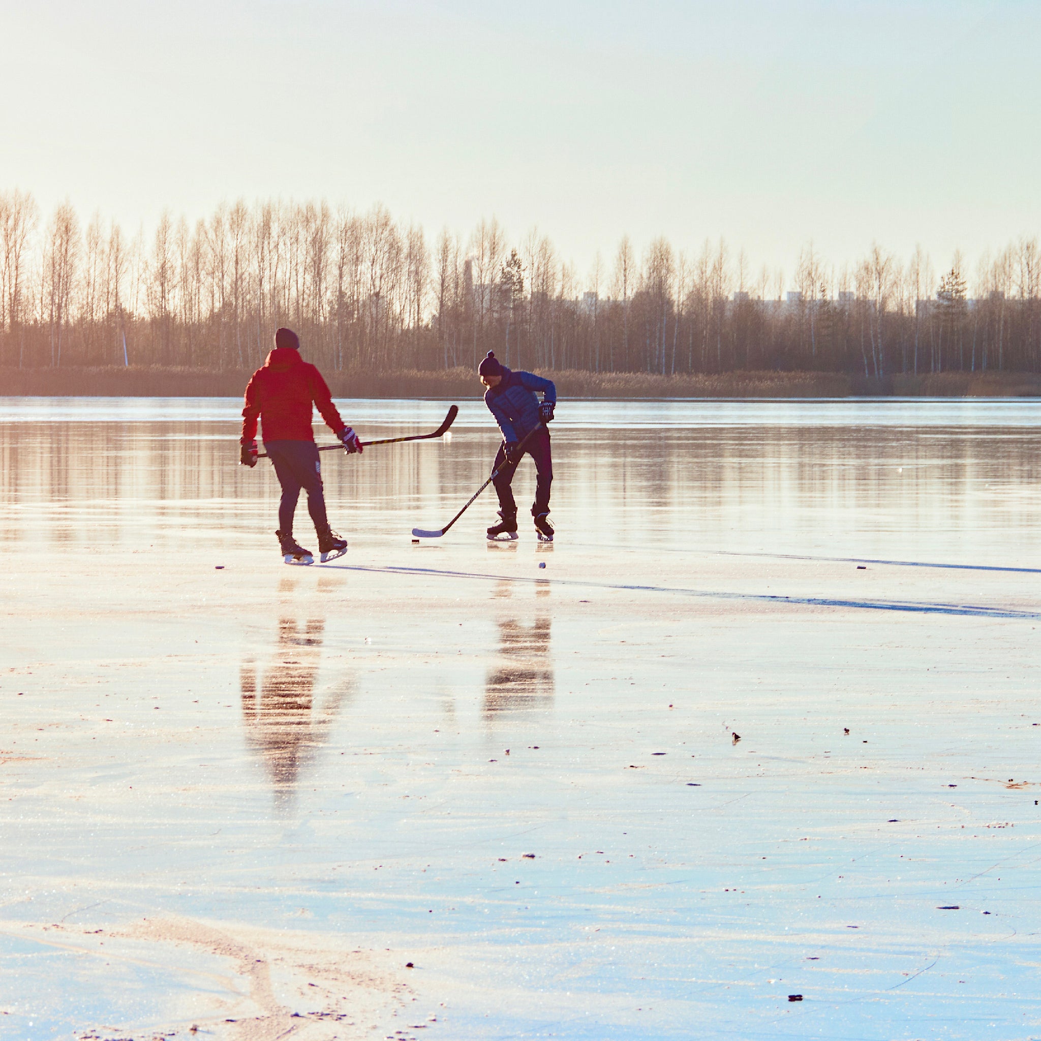 Blog banner image of two men playing hockey on a frozen lake.